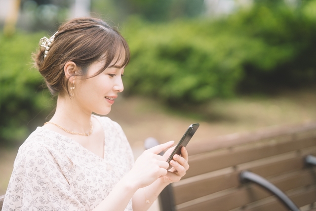 眼精疲労を改善しスマホを操作する女性