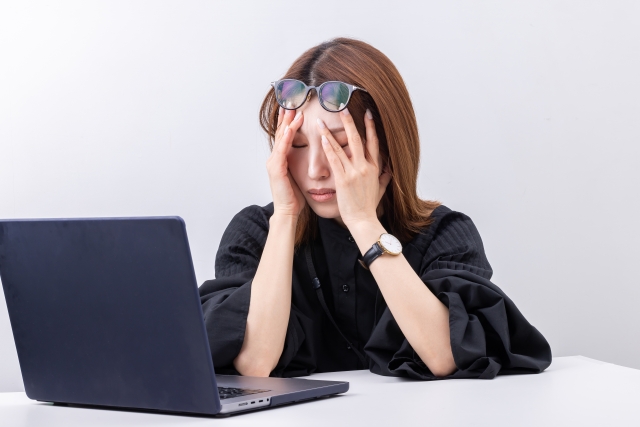 デスクワークによる眼精疲労で悩む女性