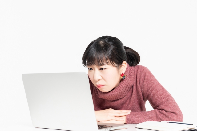 姿勢が悪いデスクワークをする女性